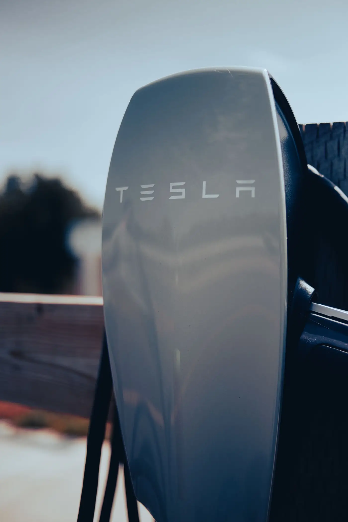 Tesla electric vehicle charging at a wall-mounted home charger